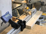 Woodworking setup with a digital measuring device on a table saw.